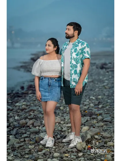 A casual, relaxed pose on the rocky riverbank. This photo captures a quiet moment of the couple just being themselves and taking in the scenery.