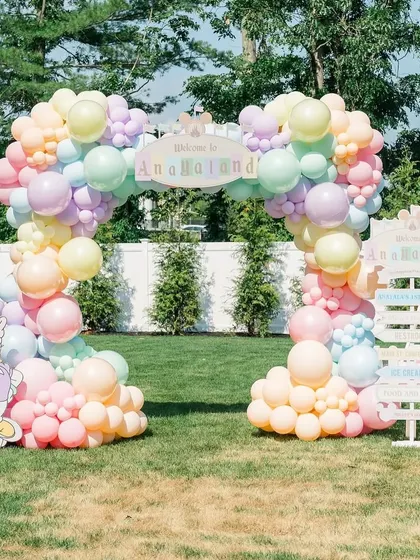 A duplicate of ID 81, showing the full entrance arch and welcome sign in the sunny garden.