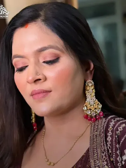 This close-up shows a soft, rosy makeup look. The pink tones on the eyes and cheeks create a fresh, monochromatic style that is very modern.