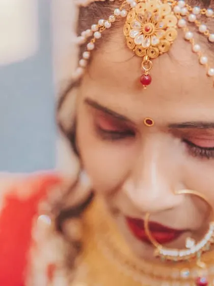 A close-up of a bride getting ready, showcasing her beautiful matha patti and traditional bridal makeup. These are the final touches before she walks down the aisle.