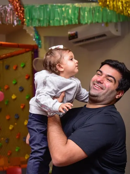 Cuddles of joy. A father lifts his daughter up, sharing a happy and playful moment during a party.