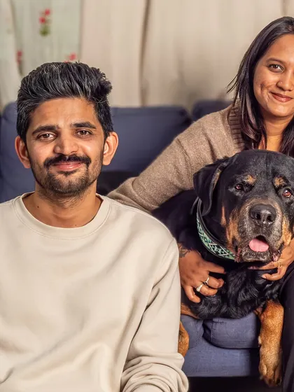 A classic family portrait with their handsome Rottweiler, Jag. Everyone is relaxed and happy, showing the comfortable bond they all share.