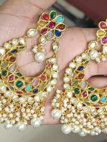 A stunning pair of Navratan chandbali earrings with pearl drops. The vibrant colours and traditional design make these a must-have for any jewellery lover.