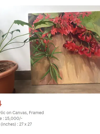An acrylic painting of red flowers, seen here resting against a wall next to a houseplant. This shows how a finished piece looks before it is hung, ready to bring life to a new space.