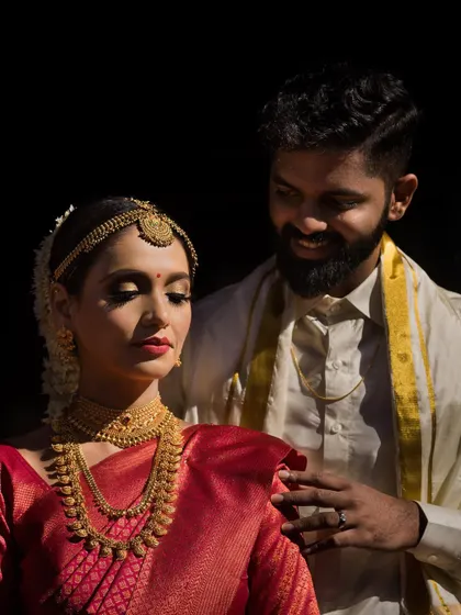 An intimate portrait of the couple, with the groom looking lovingly at the bride, captured with dramatic lighting.