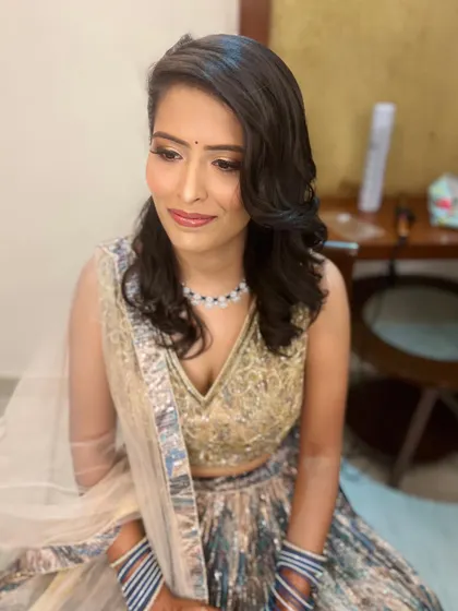 A three-quarter view of this elegant engagement look, showing the soft hairstyle and glowing makeup.
