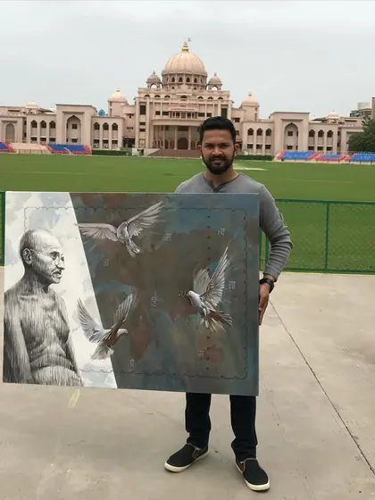 Holding my painting of Gandhiji at the camp. It was a powerful experience to create this piece in a place so connected to his life.