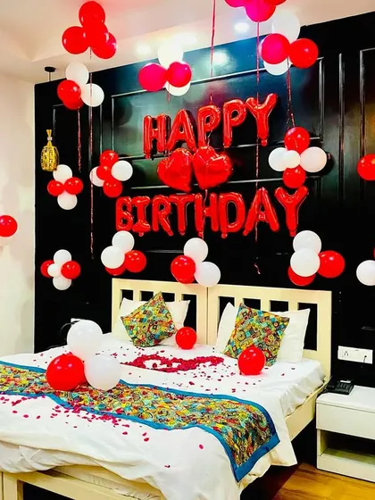 A well-lit photo of the red and white romantic bedroom decoration, showing the neat arrangement of the foil balloons and the clusters on the wall.