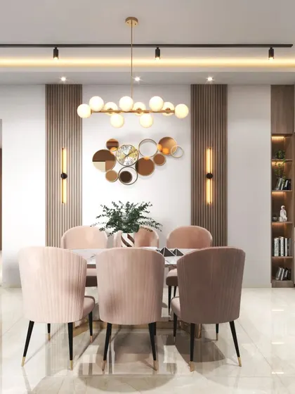 This dining space uses soft blush tones in the chairs and metallic accents in the lighting and decor to create a warm and glamorous atmosphere.