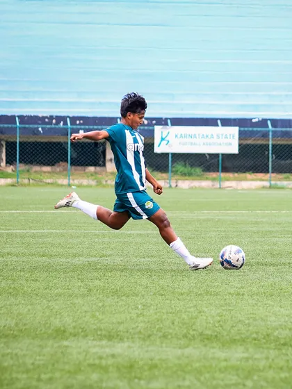 A player executes a perfect kicking technique, striking the ball with power and precision during a match.