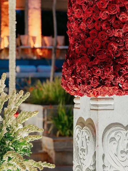 A pillar on the mandap is wrapped in a dense arrangement of thousands of red roses, a testament to our meticulous floral work.