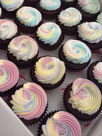 A full box of unicorn-themed cupcakes. The magic is in the pastel rainbow buttercream swirls, which I pipe onto each chocolate cupcake to match the unicorn party theme.