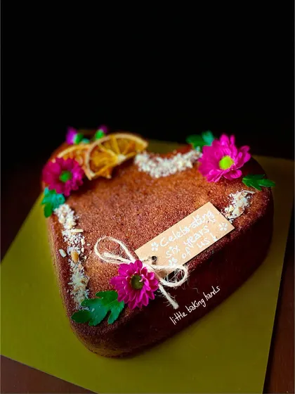 Nothing says "I love you" better than a heart-shaped cake. This is an orange gulkand nuts cake with a customized tag, perfect for an anniversary.