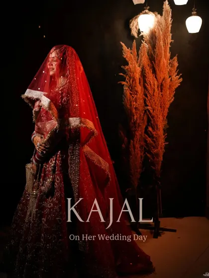 A full-length portrait of the bride under her veil, set against a dark background with pampas grass decor, creating a modern and chic bridal shot.
