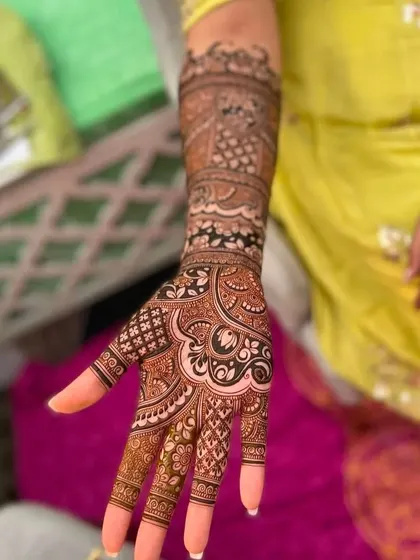 A close-up of a detailed design on the palm and arm. The mix of floral, paisley, and geometric patterns creates a rich and textured look.