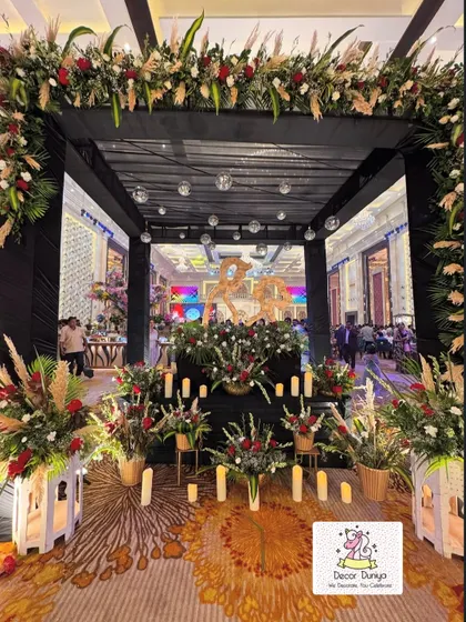 A chic and modern entrance for a cocktail party. The black canopy decorated with disco balls, pampas grass, and red roses sets a glamorous tone for the evening.