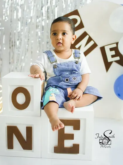 A sweet moment of this little one sitting atop the 'ONE' blocks. The soft lighting and simple props keep the focus entirely on the birthday boy.