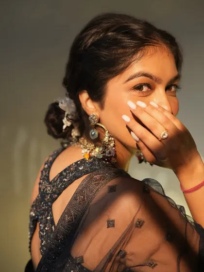 A close-up on the back details and accessories for this lehenga look. The criss-cross back design adds a modern touch, while the traditional earrings complete the festive ensemble.