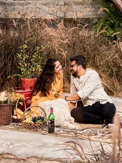 A cozy picnic scene in a rustic, grassy setting, perfect for a relaxed and intimate pre-wedding shoot.