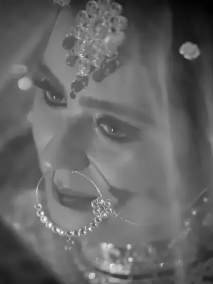 A soft and ethereal black and white bridal portrait. The bride is seen through her veil, creating a dreamy, timeless, and romantic image.