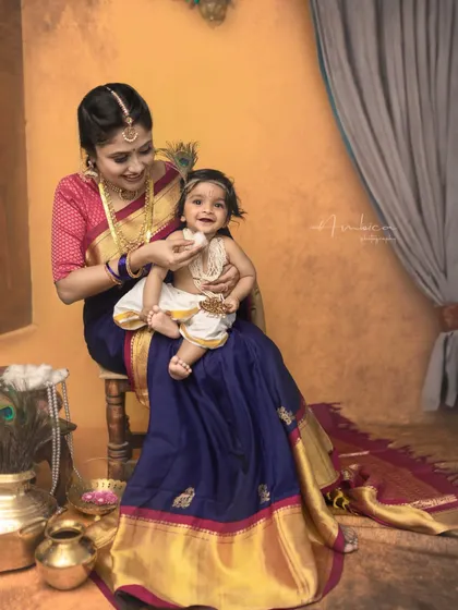 A joyful interaction between mother and son during their Krishna photoshoot. Her smile as she feeds him captures the essence of a mother's love.