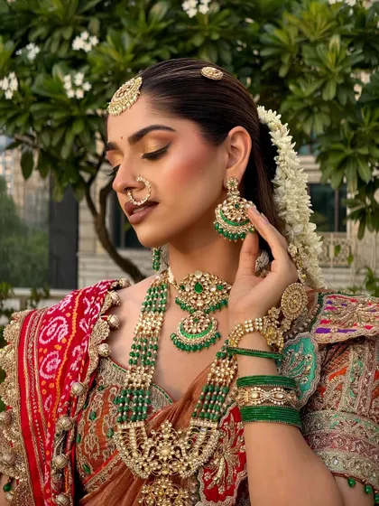 A side profile showcasing the beautiful gajra (floral hair accessory) and the intricate details of the makeup and jewellery.