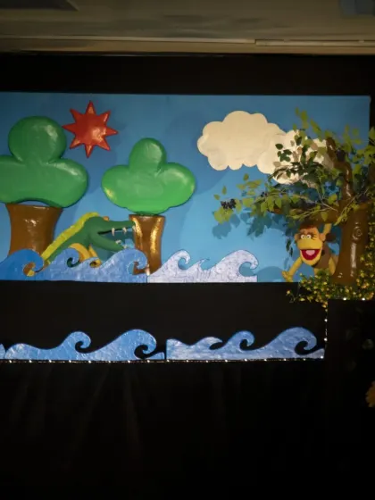 The clever monkey hides in a tree from the crocodile in this scene from the classic Panchatantra tale. The use of rod puppets allows for dynamic movement across the stage.