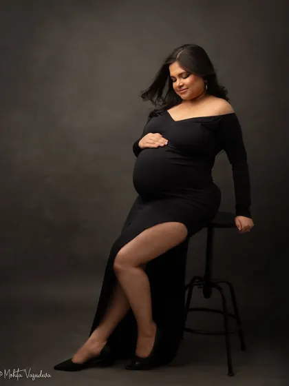 A powerful and chic seated pose in a black gown. This look is modern, confident, and utterly stunning.