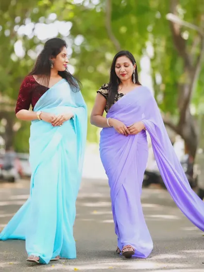 A walking shot of two models in the blue and lavender trail sarees, showing how they flow together.