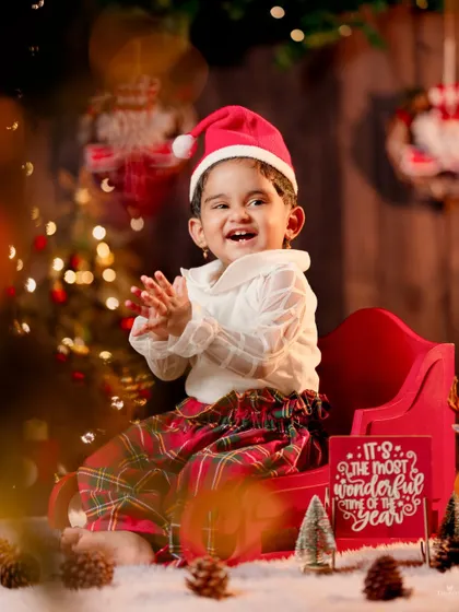 The pure joy of Christmas. This toddler's happy, clapping expression is perfectly captured in this festive sleigh setup.