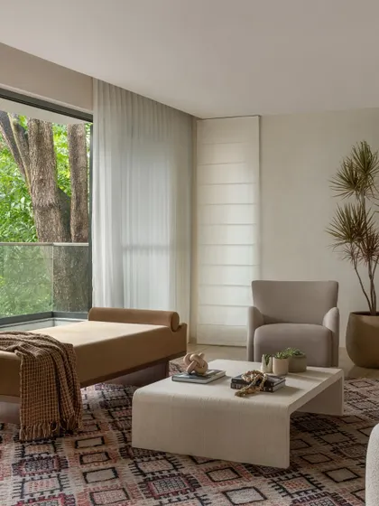 In this space, a modern daybed helps to define the seating area while maintaining an open and airy feel. The large window connects the room to the lush greenery outside.