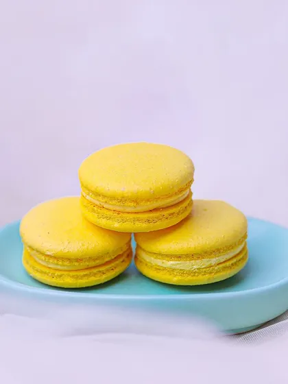 A stack of our Mango Macarons, filled with luscious mango buttercream and a jelly center. A true taste of summer.