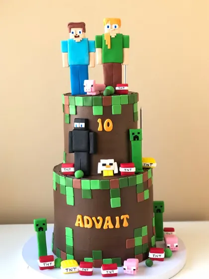 A massive two-tiered Minecraft cake, with a chocolate frosting base and lots of characters and game elements.