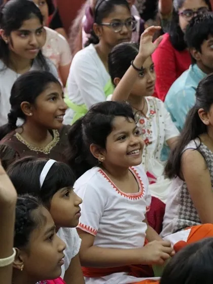 Children eagerly raising their hands to participate. We create a safe and encouraging space for them to share their thoughts and ideas.