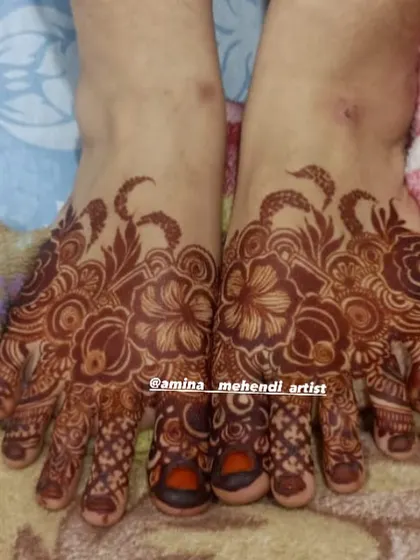 A rich, dark stain on a detailed floral foot mehendi design.