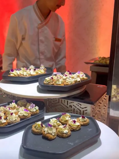 A display of elegant canapés on modern black platters. Our buffet spreads often include a mix of hot and cold items, as well as pre-plated small bites for easy service.