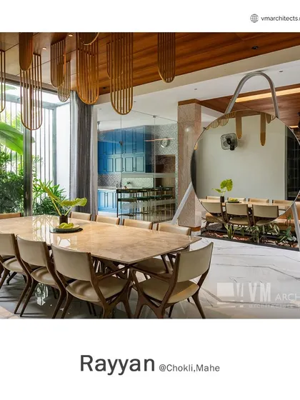 The dining area at Rayyan is a study in modern luxury, with a marble-topped table, a statement mirror, and custom pendant lights under a wooden ceiling.