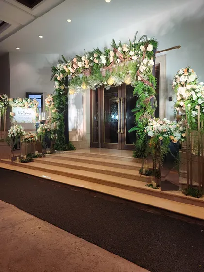 Another angle of the romantic floral entrance, showing the welcome sign and accompanying arrangements. The cohesive design creates a fully immersive experience for arriving guests.