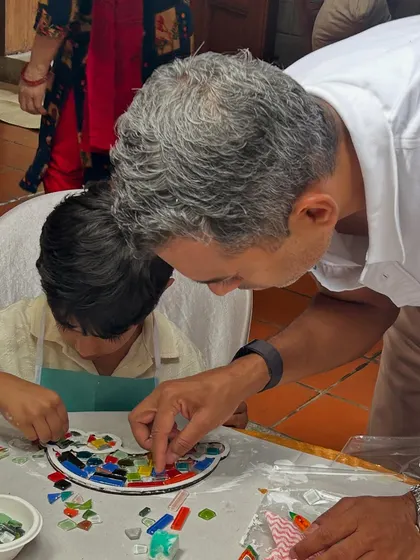 A father and son bonding over a creative project. It's wonderful to see parents get involved and help their kids create their mosaic masterpieces.