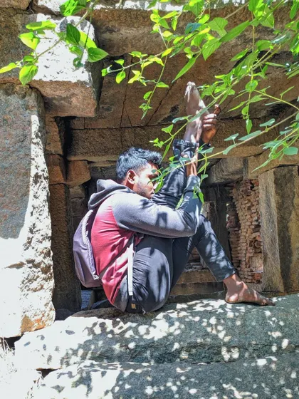 A deep hip-opening stretch, Akarna Dhanurasana (Archer Pose), while sitting in the window of an old stone structure. I let my body talk and explore its own range of motion.