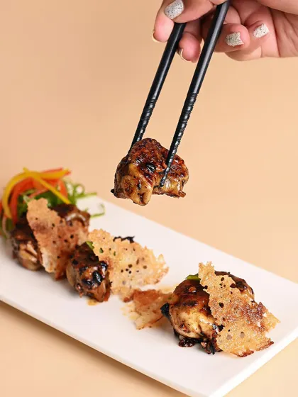 My Chicken Gyoza are pan-fried to perfection, tossed in a house-made chili bean jam, and served with a crispy net for extra crunch. You'll love them.