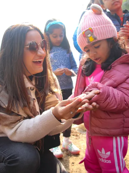 A mother and daughter share a happy moment, showcasing the joy of connecting with nature and each other at the farm.
