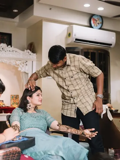 A wider shot of the home mehendi ceremony. It shows the intimate, relaxed atmosphere of celebrating at home with your closest family.