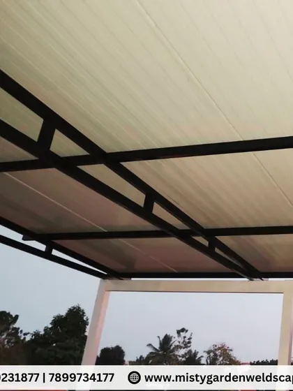 The underside of a puff sheet pergola at a villa in Whitefield. The clean white finish of the panels and the black metal frame create a modern and minimalist look.