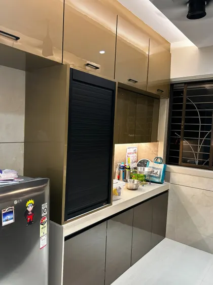 A close-up of a kitchen with a built-in appliance garage featuring a black rolling shutter. This is a perfect way to keep small appliances accessible but out of sight, maintaining a clean and organized countertop.