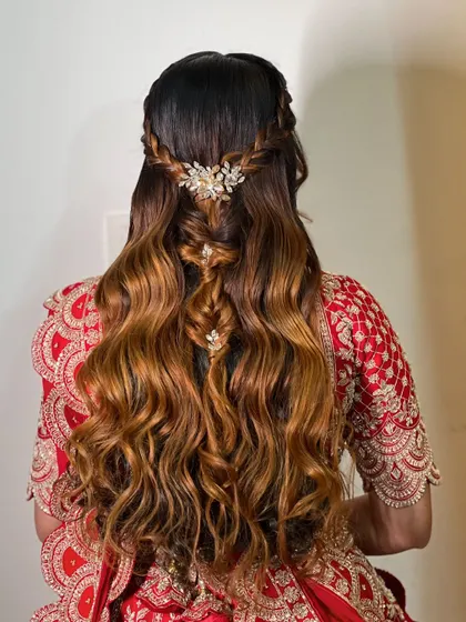 The ombre hair color beautifully enhances the texture of the waves and braids in this modern half-updo.