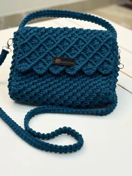 A beautiful teal sling bag with a scalloped flap. The color is so rich and eye-catching.