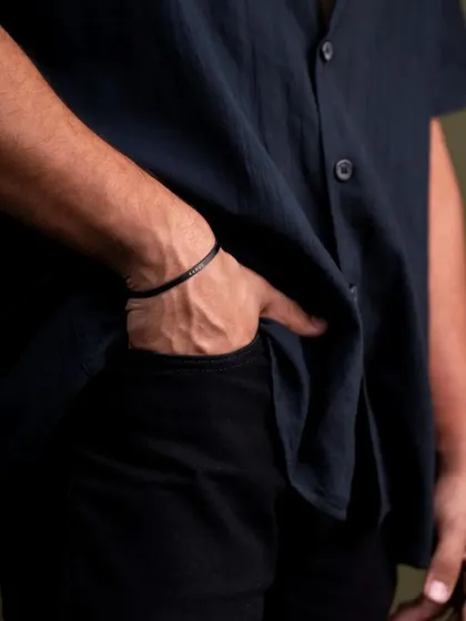 This is a subtle lifestyle shot focusing on how a men's bracelet looks when worn. The casual pose with the hand in the pocket makes the accessory feel natural and effortlessly stylish, helping customers visualize it on themselves.