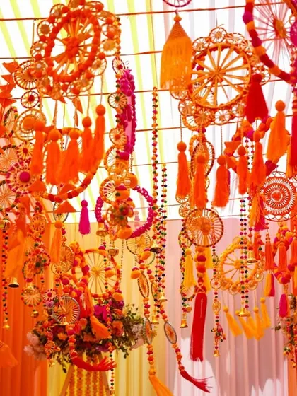 The ceiling was a spectacle of its own. We created a dense canopy of handcrafted hangings, including dreamcatchers, tassels, and bells in shades of orange and pink, for a truly festive feel.