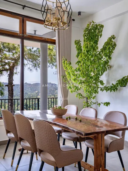 Another perspective of the dining room in Mukteshwar, highlighting the live-edge solid wood table that brings a natural, rustic element into the elegant space.
